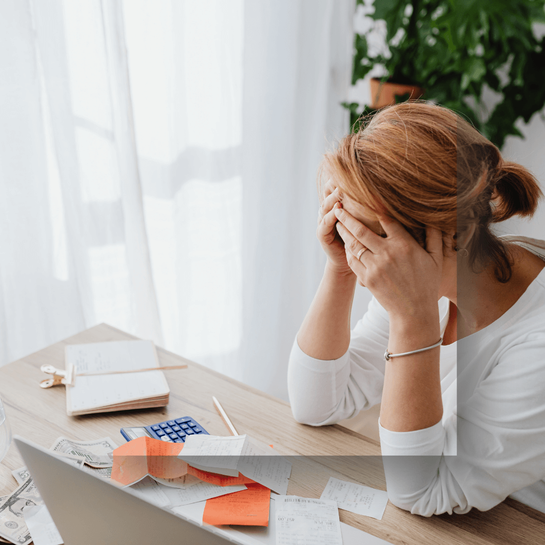Woman at her desk surrounded by post it nots, diary open looking overwhelmed at your invisible workload
